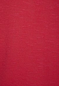 Roter gestrickter Stoff mit einer feinen Textur, der eine subtile Farb- und Mustervariation aufweist und eine einheitliche Oberflächenoptik schafft.