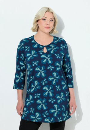Marineblaues Tunika mit floralen Mustern in Teal und helleren Blautönen, mit rundem Halsausschnitt und einem Schlüssel-Loch-Detail sowie dreiviertellangen Ärmeln.