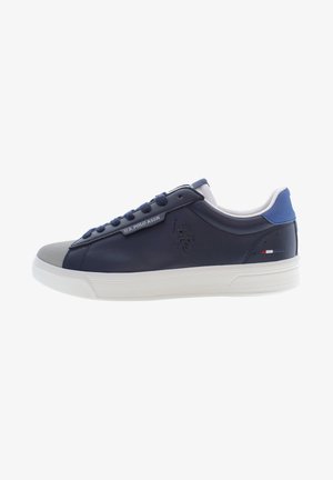 Sneaker blu navy in pelle sintetica con punta grigia, suola bianca e dettaglio del logo sul lato. Presenta un design con lacci e colletto imbottito.
