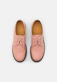 Chaussures en cuir rose avec un bout arrondi, des lacets en cuir, une semelle perforée et une semelle noire avec un détail de couture jaune.