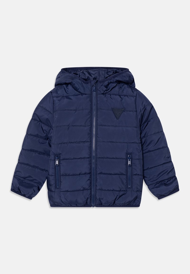 Veste matelassée pour enfants bleu marine avec capuche, fermeture éclair à l'avant, deux poches zippées et un petit patch triangulaire sur la poitrine.