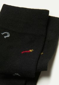 Black socks with ribbed texture, featuring colorful chili pepper and flame motifs in red, yellow, and gray. Classic design suitable for casual wear.