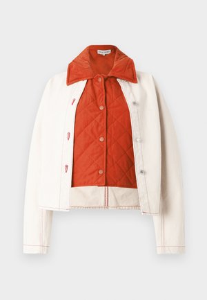White jacket with a quilted orange lining, featuring a large collar, snap buttons, and contrasting red stitching along the seams.