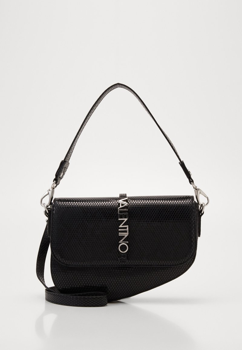 Black textured leather shoulder bag with silver VALENTINO logo clasp, curved asymmetrical flap, and detachable strap on white background.
