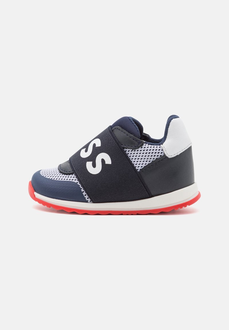 Basket bébé bleu marine et blanc avec semelle rouge, tissu en mesh et large sangle élastique noire avec lettres blanches "SS" sur le dessus.