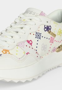 Λευκό sneaker Guess με πολύχρωμα λουλουδένια σχέδια, άσπρα κορδόνια, χρυσό λογότυπο "Guess" και χοντρή ραβδωτή σόλα.