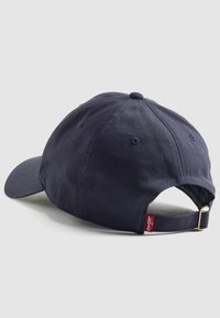 Casquette de baseball bleu marine en coton avec une visière courbée, fermeture à strap ajustable à l'arrière, et une petite étiquette rouge Levi's.