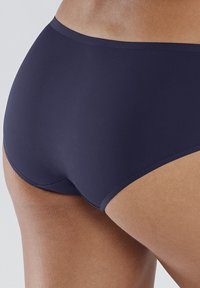 Slip bikini blu navy realizzato in tessuto liscio, con un design semplice dai bordi morbidi e senza hardware o dettagli visibili.