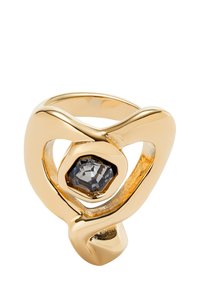 Bague en or avec des bandes lisses entrelacées et une pierre hexagonale sombre au centre. Le design présente un espace ouvert, créant une silhouette unique.