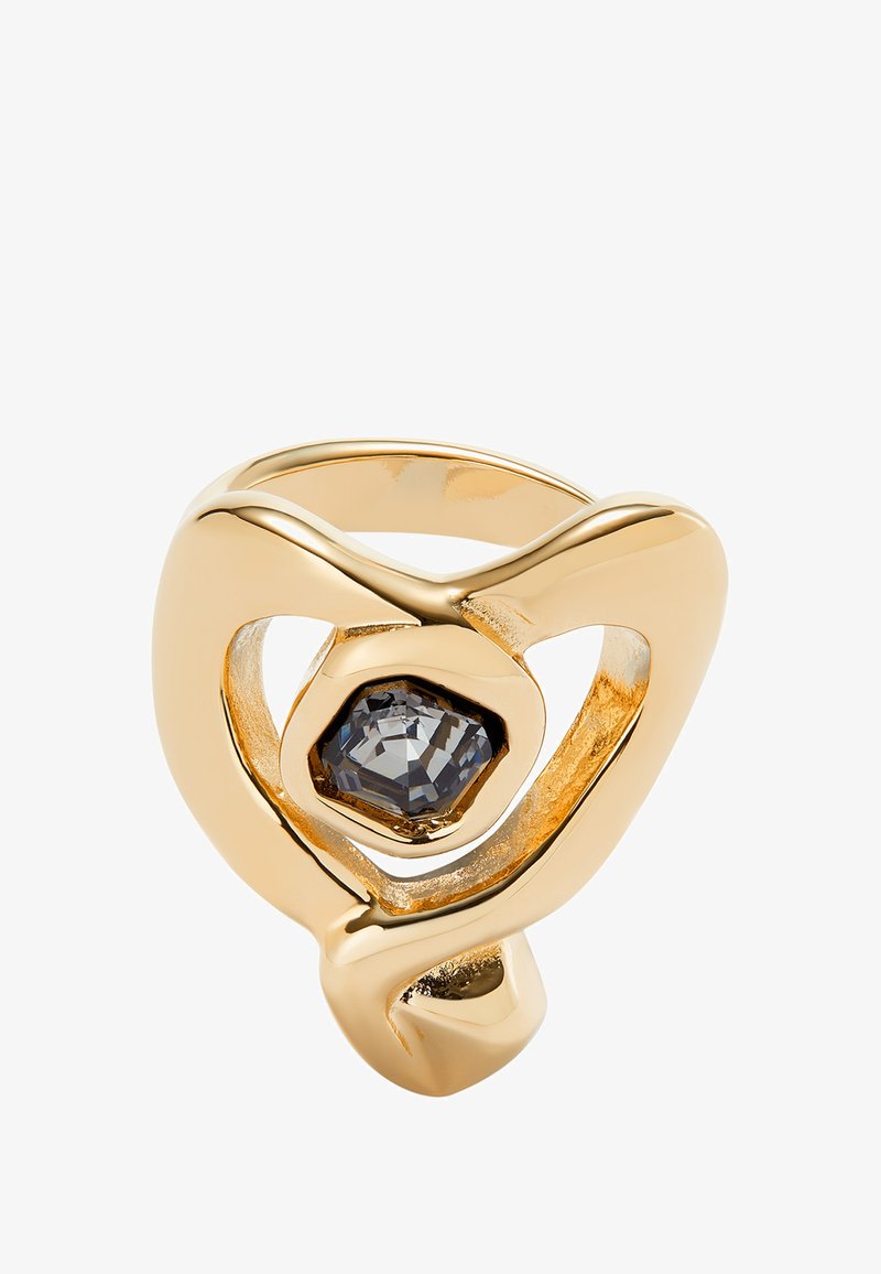 Bague en or avec des bandes lisses entrelacées et une pierre hexagonale sombre au centre. Le design présente un espace ouvert, créant une silhouette unique.