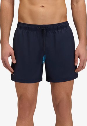 Torace e gambe maschili che indossano pantaloncini da bagno blu navy con elastico in vita e coulisse con punte blu annodate al centro davanti.