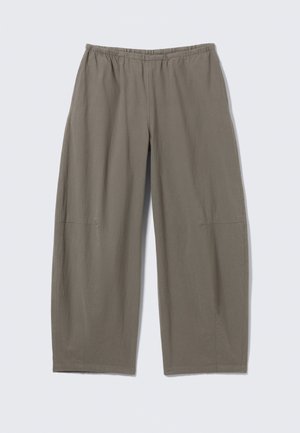 Lahke lõikega, sirgete sääreosadega püksid tuhmunud oliivrohelisest kangast, kummist vöökohaga, esitatud lihtsal heledal hallil taustal.