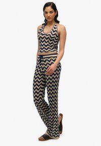 Halterneck top en wijde broek in een marineblauw en crèmekleurig zigzagpatroon. Zachte stof met een ontspannen pasvorm, met een verstelbare trekkoord in de taille.