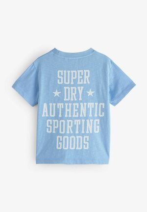 Blå bomullströja med stort vitt tryck som läser "SUPER DRY AUTHENTIC SPORTING GOODS" med stjärnor på baksidan. Klassisk passform.