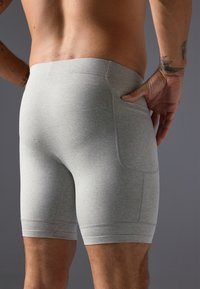 Boxers gris en tissu doux, au design ajusté, avec des coutures plates et une poche arrière dotée de détails de couture discrets.