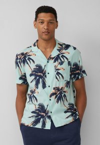 Korte mouw, muntgroene overhemd met knopen en een navy palmbomenprint, een borstzak en een relaxte pasvorm. Glad stofoppervlak.