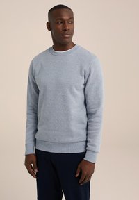 Sudadera gris claro con cuello redondo y manga larga. Presenta puños y dobladillo de canalé, fabricada en suave algodón texturizado.