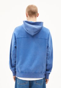 Felpa blu con cappuccio, dal design rilassato, realizzata in tessuto morbido, con tasca a canguro e polsini a costine, mostrata dal retro.