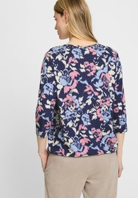 Blumen-Pullover aus navyfarbigem Stoff mit rosa und blauen Blumenmustern; mit Rundhalsausschnitt und dreiviertellangen Ärmeln.