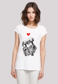 Weißes Baumwoll-T-Shirt mit einem schwarz-weißen Skelettgrafik und einem roten Herzen, mit kurzen Ärmeln und einer lockeren Passform.