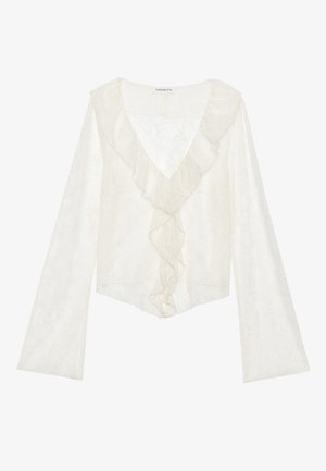 Λευκό τοπ από δαντέλα με βαθύ V-λαιμό και ριχτό μπροστινό μέρος. Μακριά μανίκια με φαρδιά σχεδίαση δημιουργούν μια ρευστή σιλουέτα.