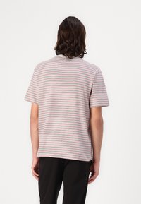 Striped short-sleeve t-shirt featuring thin red, blue, and gray horizontal lines on a light background, made of soft cotton fabric.