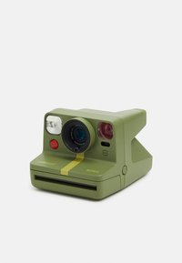 Green plastic instant camera features a round lens, red button, flash, and a yellow stripe. Compact shape with a film slot at the bottom.