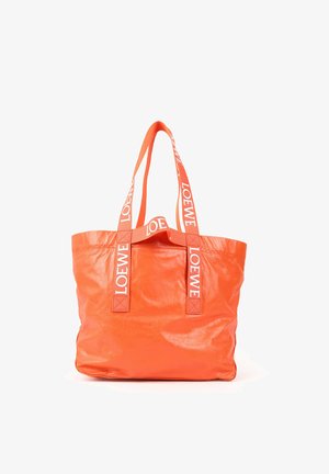 Grand sac cabas orange brillant avec de longues anses, comportant le texte blanc « LOEWE » sur les sangles, sur fond blanc.