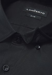 Czarna koszula o teksturowanej powierzchni i dopasowanym kroju. Posiada kołnierzyk z guzikami oraz czarne guziki. Etykieta z napisem "LANCERTO SLIM".