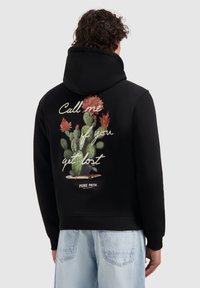 Zwarte hoodie met een textuurgraphic van cactussen en bloemaccenten op de achterkant, met witte tekst die zegt: "Bel me als je verdwaald bent."