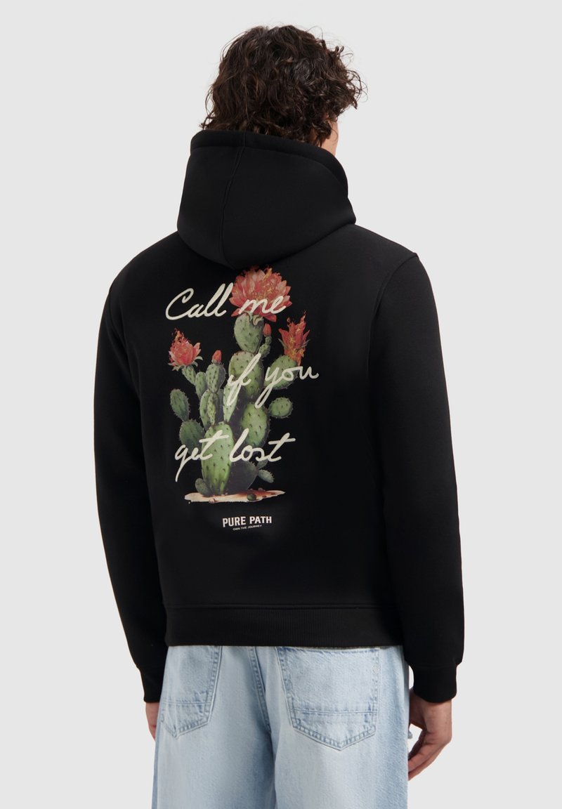 Zwarte hoodie met een textuurgraphic van cactussen en bloemaccenten op de achterkant, met witte tekst die zegt: "Bel me als je verdwaald bent."