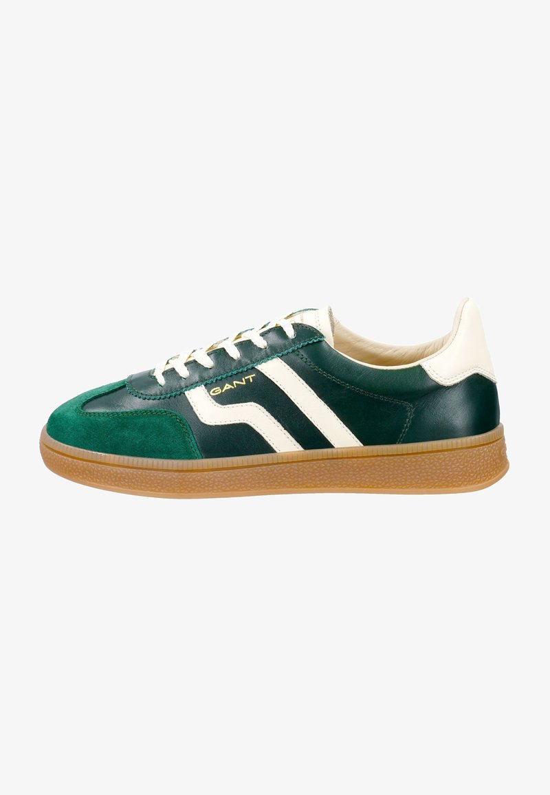 Green and black leather sneakers with white stripes, cream accents, and a gum sole; features laces and branding on the side.