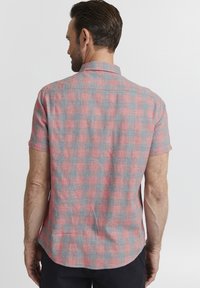 Camicia a maniche corte a quadri rossa e grigia, con colletto button-down e taglio dritto con spacchi laterali per comfort e traspirabilità.