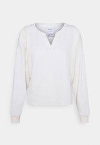 Witte longsleeve pullover met een textuurpatroon, V-hals en geribde manchetten. Glad stof met een ontspannen pasvorm en iets kortere lengte.