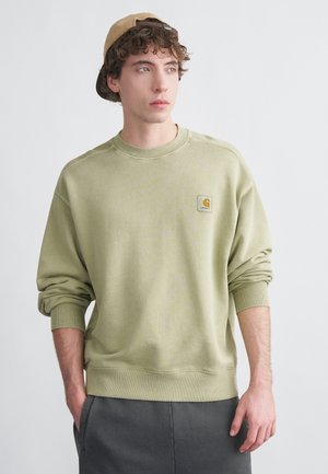 Sweat-shirt vert clair avec une finition texturée, doté d'un col rond et de poignets côtelés. Comprend un patch logo carré sur la poitrine.