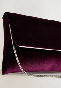 Pochette en velours violet au design épuré, forme triangulaire, détail en métal argenté et fermeture éclair sur le bord.