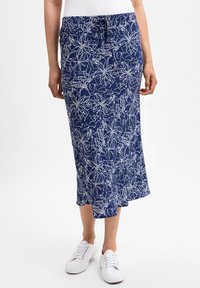 Navyblaue, knielange Röcke mit einem weißen abstrakten Muster, elastischem Bund, verstellbarem Kordelzug und einem ausgestellten Saum. Kombiniert mit weißen Sneakers.