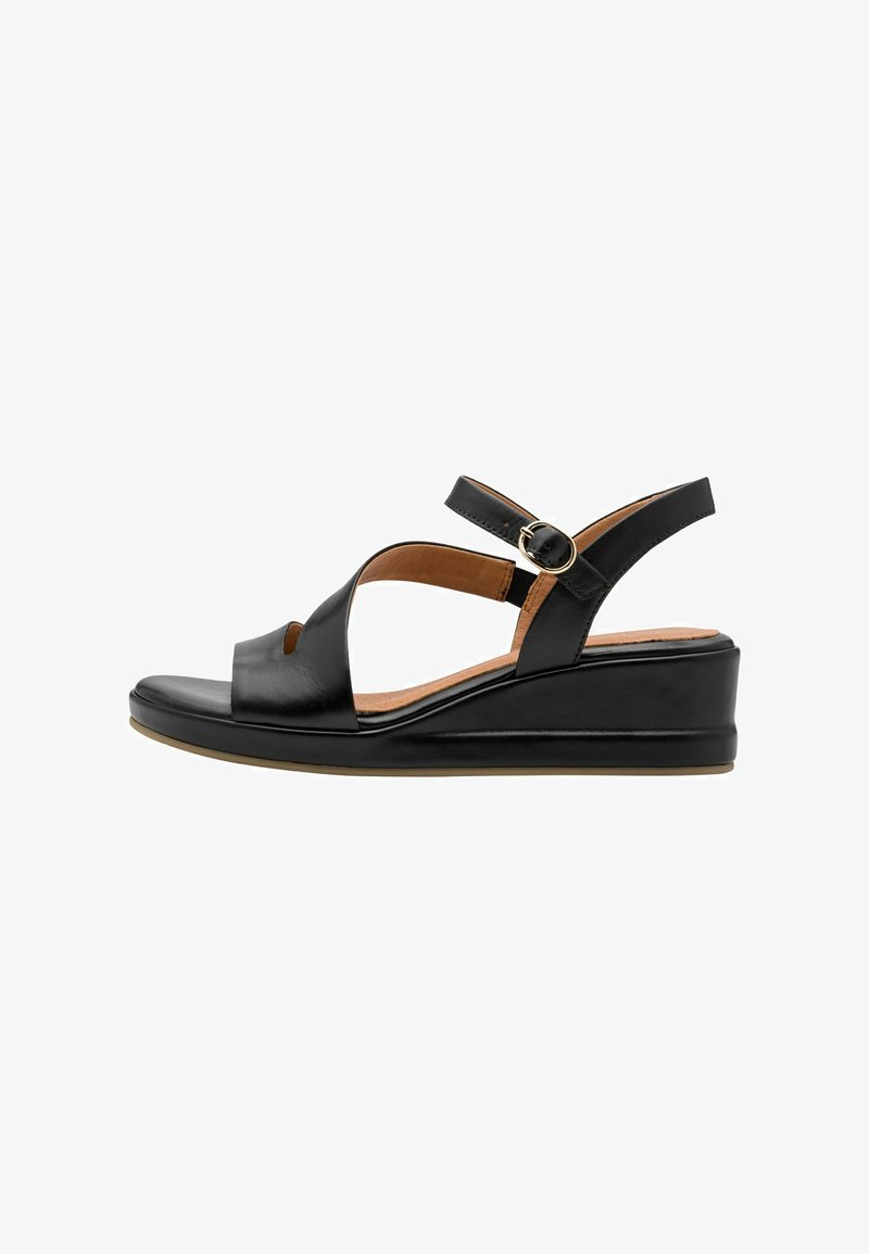 Sandales compensées en cuir noir avec des brides croisées, un bout ouvert, une sangle de cheville ajustable avec une boucle dorée, et une texture lisse.
