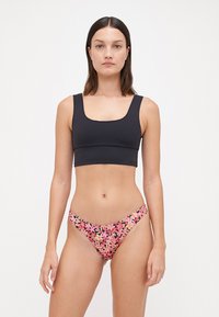 Črn bikini top s kvadratnim izrezom v kombinaciji z rožnatim bikini dnom s cvetličnim vzorcem, ki ima prilegajočo se zasnovo in gladko teksturo tkanine.