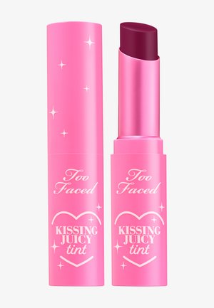 Roze lippenstift tube met een glanzende afwerking, versierd met decoratieve sterren. De dop onthult een diep bessenkleurige getinte lippenbalsem. Tekst: "Too Faced Kissing Juicy Tint."