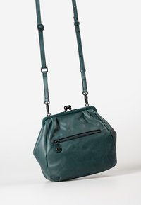 Borsa a tracolla in pelle color teal con design plissettato, tracolla regolabile e tasca con zip frontale. Presenta una chiusura a scatto nella parte superiore.