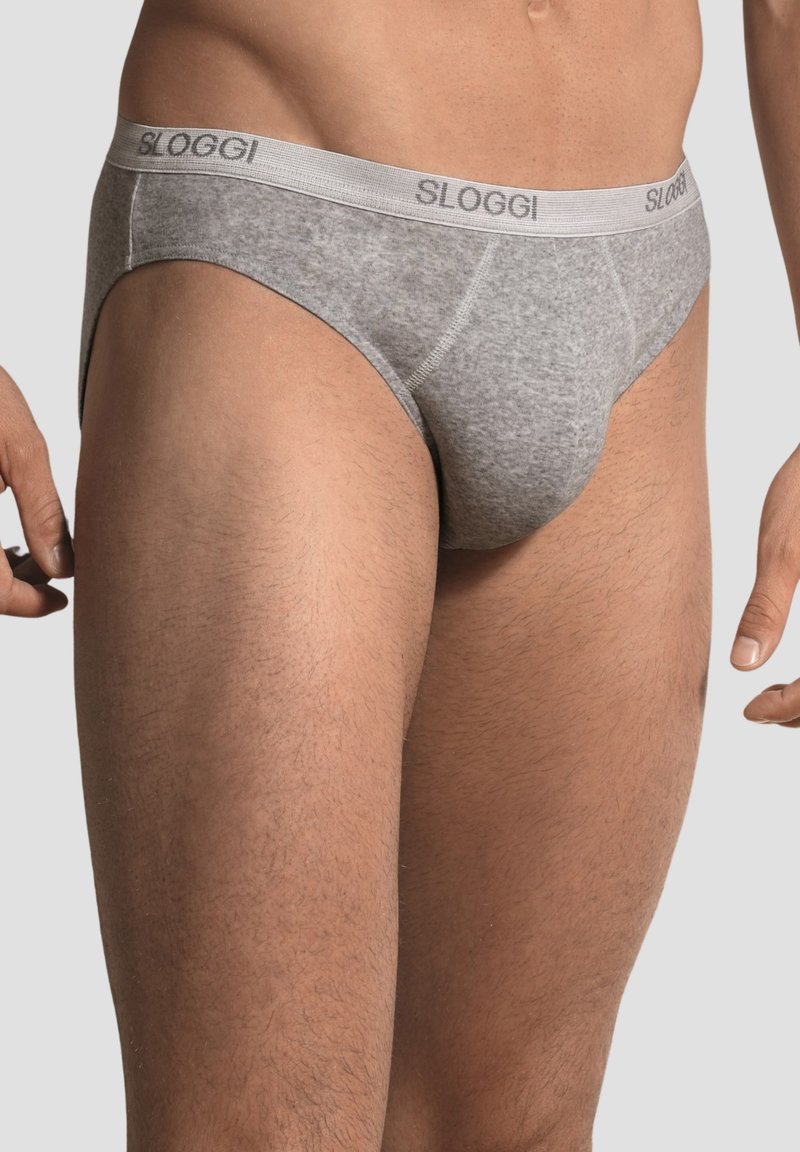 Slip grigio in cotone con una fascia etichettata "SLOGGI." Presenta una trama liscia e un taglio classico. Senza motivi visibili o componenti metallici.