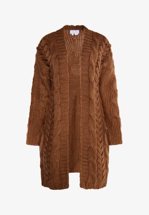 Ruskea neulecardigan, jossa on paksu vuorikauppaneule, pitkät hihat ja avonainen etuosa. Kankaan pinta näyttää pehmeältä ja mukavalta.