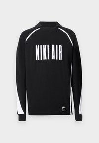 Langermet svart skjorte med hvit "NIKE AIR" tekst, kontrasterende hvite paneldetaljer på ermene, laget av myk stoff.