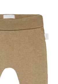 Bomullsleggings med ribbad struktur i ljusbrun färg, med en bred midjeresår och utskurna detaljer vid knäna, samt en liten varumärkesetikett på sidan.
