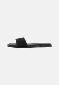 Black slide sandal with a fabric strap and flat sole. Features a subtle embossed logo on the strap and minimalistic design. Smooth texture.