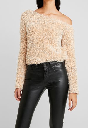 Light beige, fluffy off-the-shoulder sweater with long sleeves, paired with fitted black leather pants. Textured fabric, cropped design.