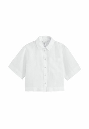 Chemise blanche courte à manches courtes, boutonnée, avec col pointu et poche poitrine, présentée sur un fond blanc uni.