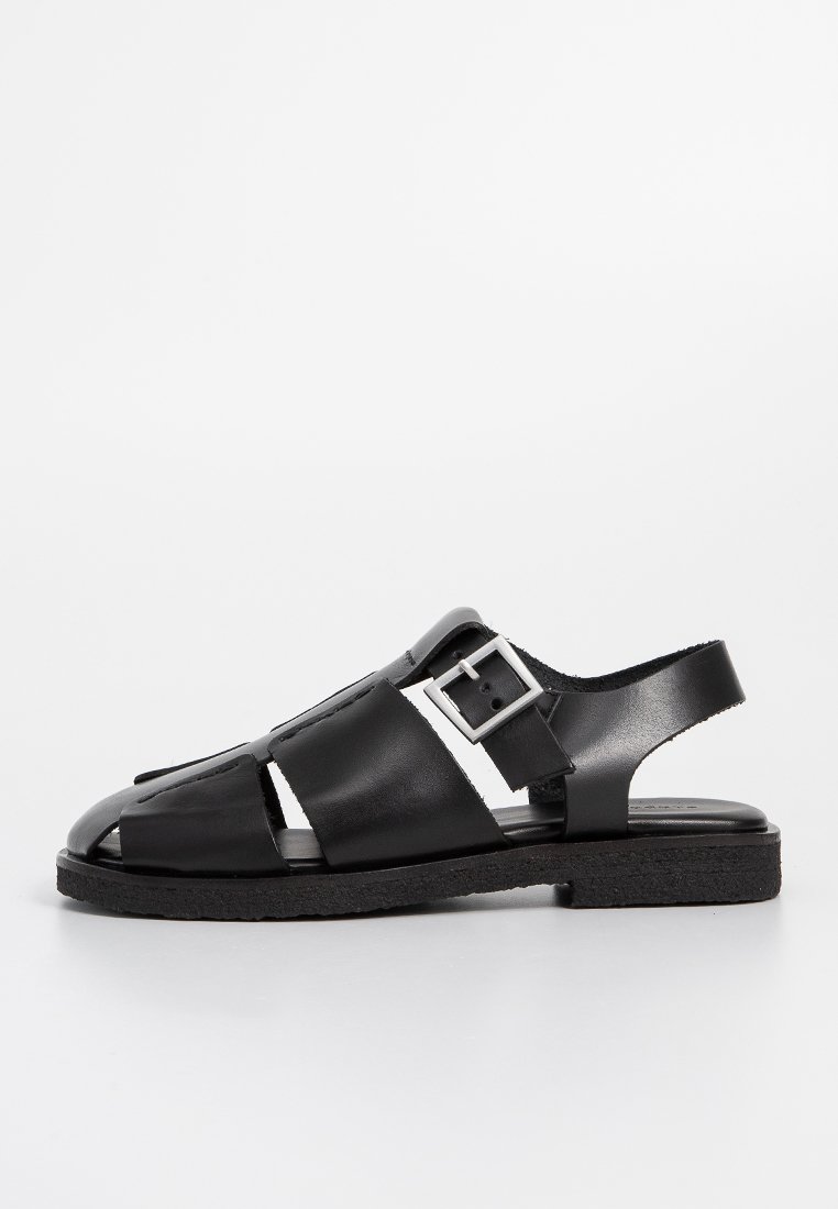 Zwarte leren sandalen met open teen, zijsluiting met gesp en een gestructureerde zool. Voorzien van kruisende banden en een slingback ontwerp.