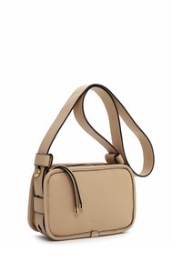 Béžová kožená crossbody taška s obdélníkovým tvarem, kontrastním černým lemem, zlatými kovovými akcenty a zipovým uzávěrem.